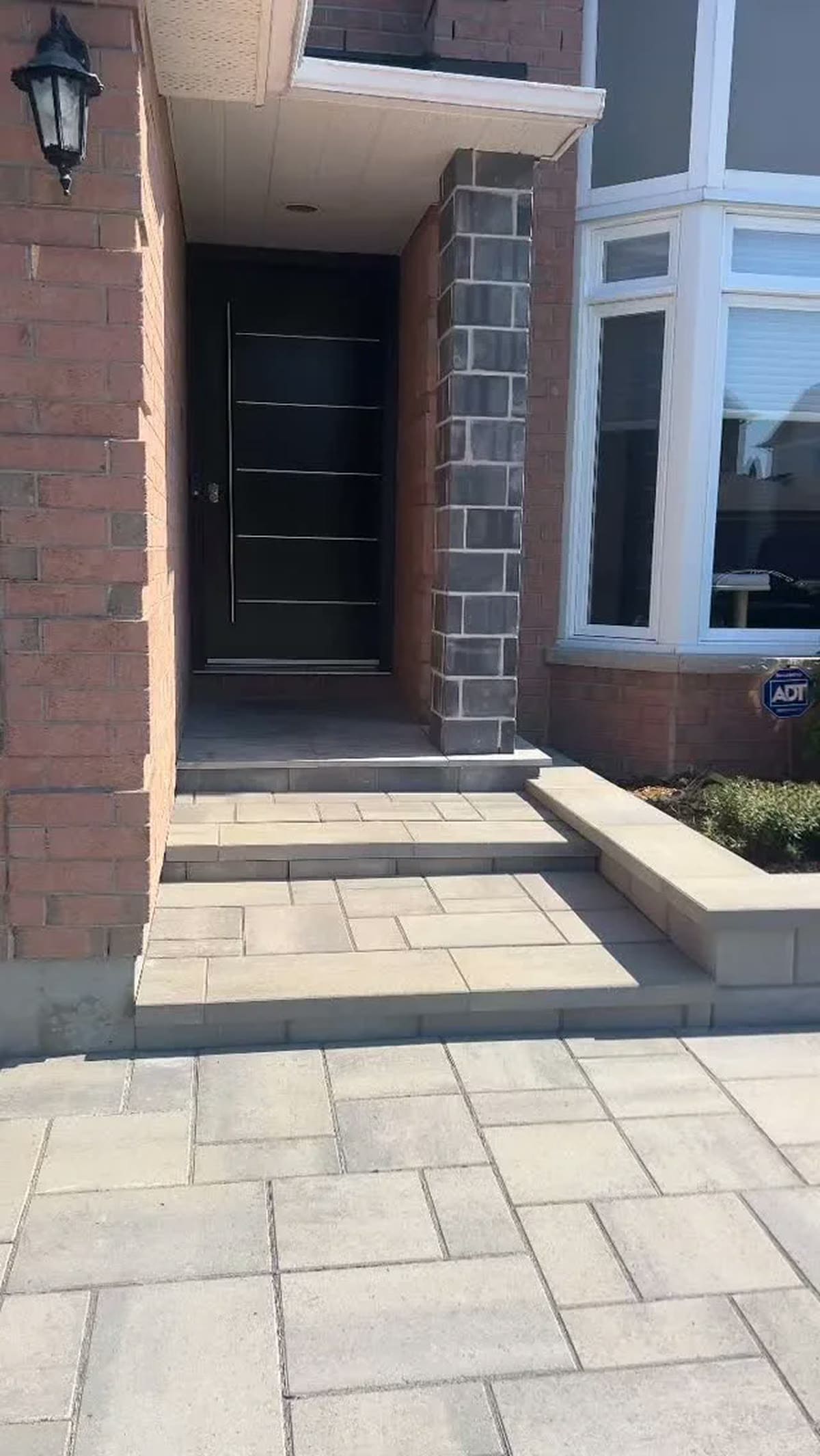 Front entrance with interlock steps and stone pillar